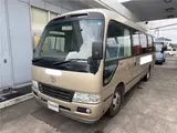 2016 Toyota Coaster 29-seater EX with automatic doors, passenger seat monitors, and refrigerators. Gold Van for sale, Japanese used car export - photo 1 of 30 | GULJI TRADERS