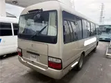 2016 Toyota Coaster 29-seater EX with automatic doors, passenger seat monitors, and refrigerators. Gold Van for sale, Japanese used car export - photo 2 of 30 | GULJI TRADERS