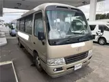 2016 Toyota Coaster 29-seater EX with automatic doors, passenger seat monitors, and refrigerators. Gold Van for sale, Japanese used car export - photo 4 of 30 | GULJI TRADERS
