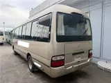 2016 Toyota Coaster 29-seater EX with automatic doors, passenger seat monitors, and refrigerators. Gold Van for sale, Japanese used car export - photo 5 of 30 | GULJI TRADERS