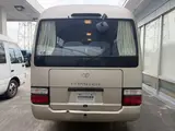 2016 Toyota Coaster 29-seater EX with automatic doors, passenger seat monitors, and refrigerators. Gold Van for sale, Japanese used car export - photo 7 of 30 | GULJI TRADERS