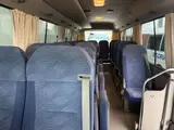 2016 Toyota Coaster 29-seater EX with automatic doors, passenger seat monitors, and refrigerators. Gold Van for sale, Japanese used car export - photo 12 of 30 | GULJI TRADERS