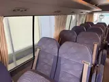 2016 Toyota Coaster 29-seater EX with automatic doors, passenger seat monitors, and refrigerators. Gold Van for sale, Japanese used car export - photo 13 of 30 | GULJI TRADERS