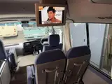2016 Toyota Coaster 29-seater EX with automatic doors, passenger seat monitors, and refrigerators. Gold Van for sale, Japanese used car export - photo 17 of 30 | GULJI TRADERS