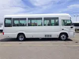 2020 Toyota Coaster Microbus LX Long 29-seater with automatic swing doors, collision mitigation, and automatic transmission. White Van for sale, Japanese used car export - photo 4 of 51 | GULJI TRADERS