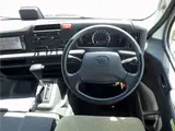 2020 Toyota Coaster Microbus LX Long 29-seater with automatic swing doors, collision mitigation, and automatic transmission. White Van for sale, Japanese used car export - photo 9 of 51 | GULJI TRADERS
