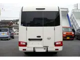 2023 Toyota Coaster LX Big Bang 9-seater White Van for sale, Japanese used car export - photo 4 of 39 | GULJI TRADERS