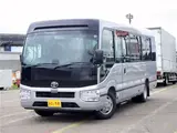 2026 Toyota Coaster Microbus GX, 28-seater, unused, current model, refrigerator, monitor. Silver Van for sale, Japanese used car export - photo 1 of 50 | GULJI TRADERS