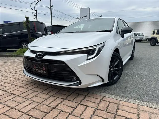 2026 Toyota Corolla 1.8 Hybrid WXB with rearview camera, ETC 2.0, and genuine front and rear dashcams. White Sedan for sale, Japanese used car export | GULJI TRADERS